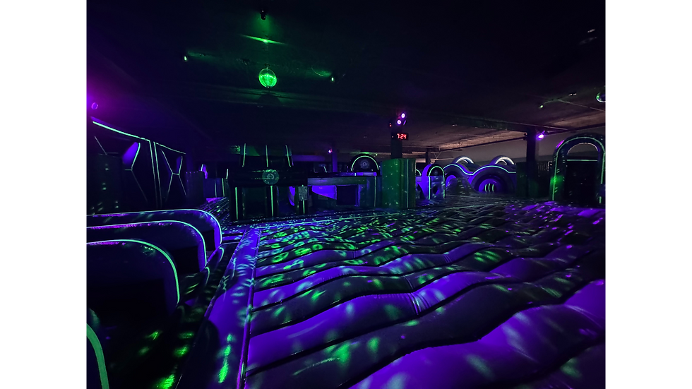 Dark room inflatable maze lit with neon colors and kids enjoying the course.