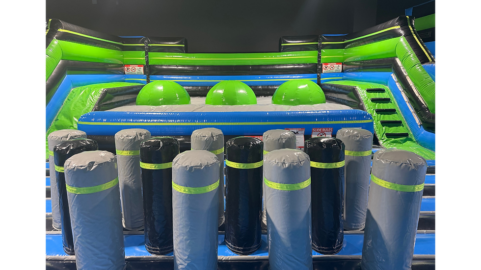 Close-up view of an inflatable challenge area with green domes and black foam bumpers.